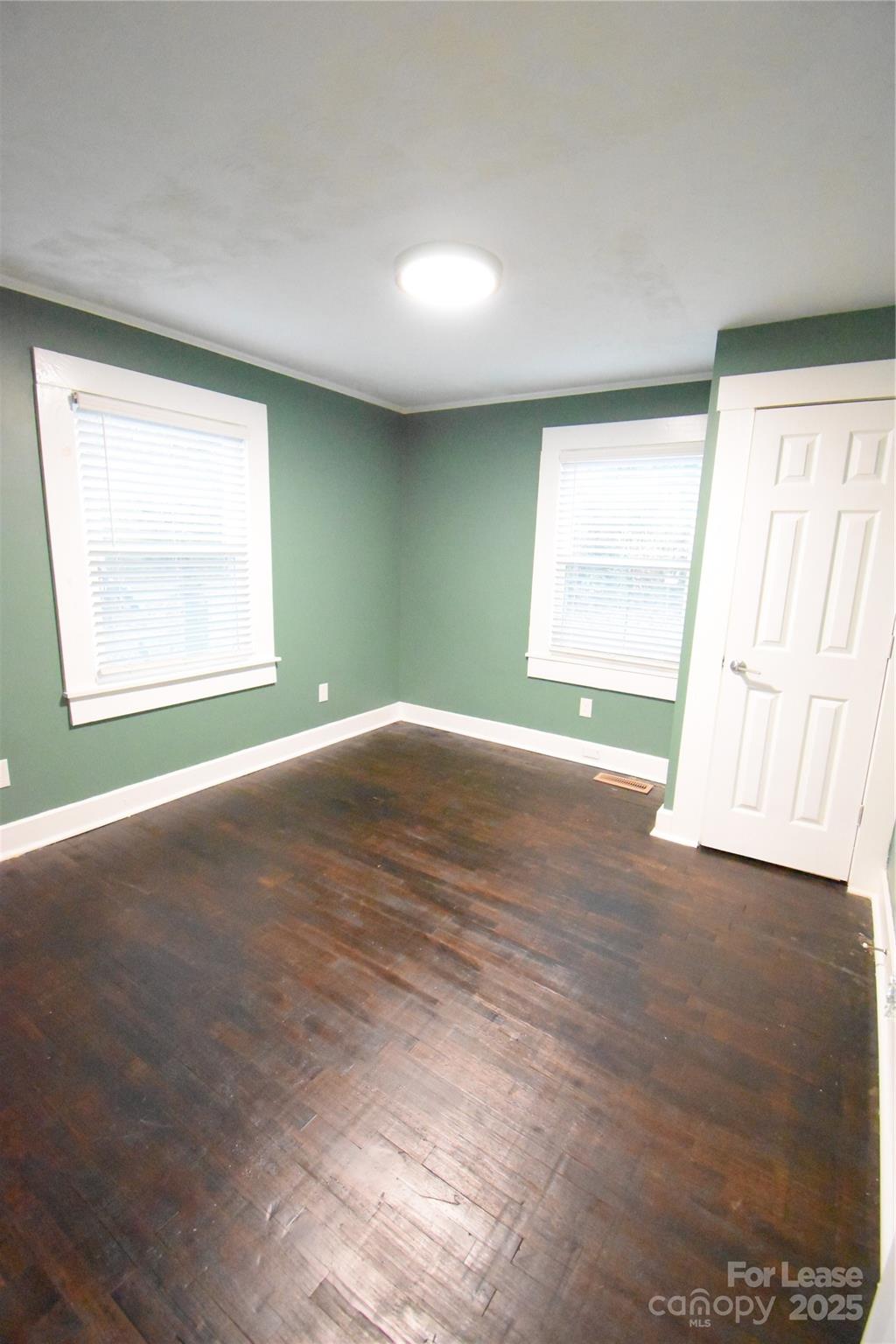 199 Crowell Drive Southwest Concord, NC 28025 - Photo 11 of 19 an empty room with wooden floor and windows