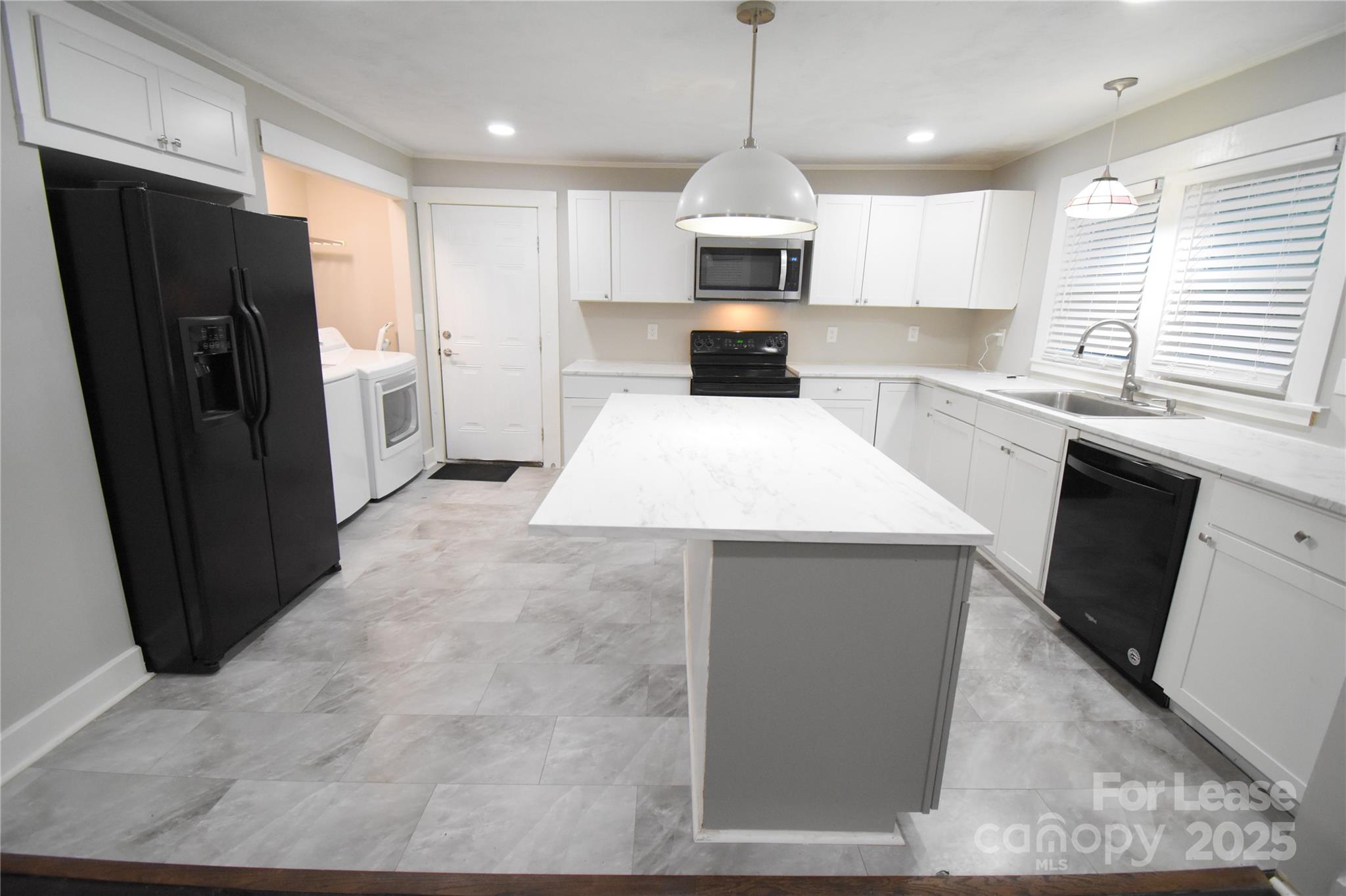 199 Crowell Drive Southwest Concord, NC 28025 - Photo 4 of 19 a large kitchen with stainless steel appliances kitchen island granite countertop a refrigerator a sink a stove a microwave and island