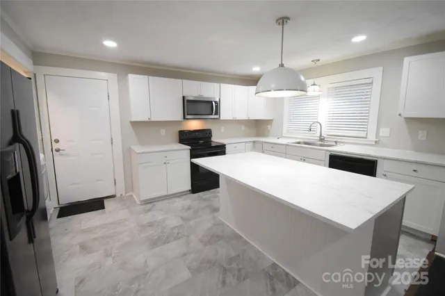 a kitchen with stainless steel appliances a microwave sink and refrigerator