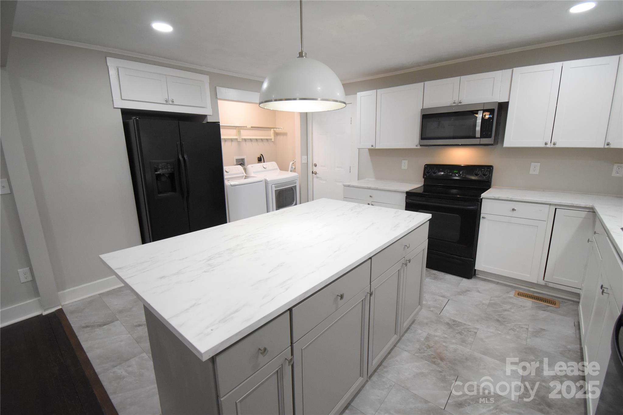 199 Crowell Drive Southwest Concord, NC 28025 - Photo 6 of 19 a kitchen with a sink a refrigerator a stove a microwave and cabinets