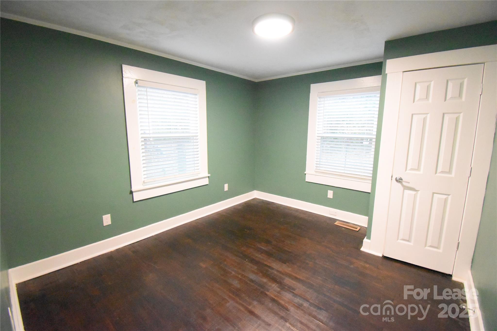 199 Crowell Drive Southwest Concord, NC 28025 - Photo 10 of 19 an empty room with wooden floor and windows
