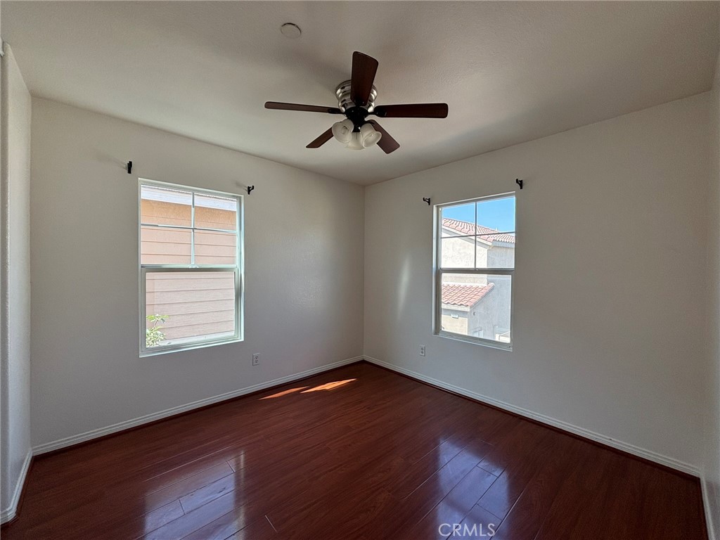 1890 Flint Court Riverside, CA 92501 - Photo 13 of 25 a view of an empty room with wooden floor and a window