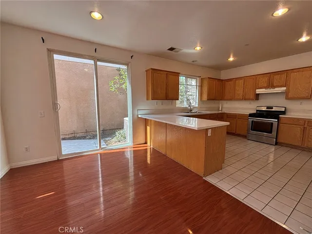 a kitchen with stainless steel appliances granite countertop a stove a sink and a refrigerator
