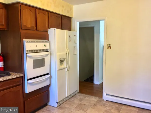 a view of a refrigerator in kitchen and wooden floor