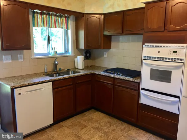 a kitchen with granite countertop cabinets washer and dryer