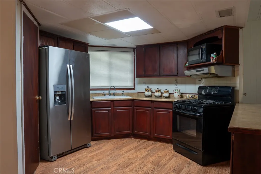 250 North Linden Avenue, Unit 248 Rialto, CA 92376 - Photo 3 of 13 a kitchen with stainless steel appliances granite countertop a stove refrigerator and a microwave