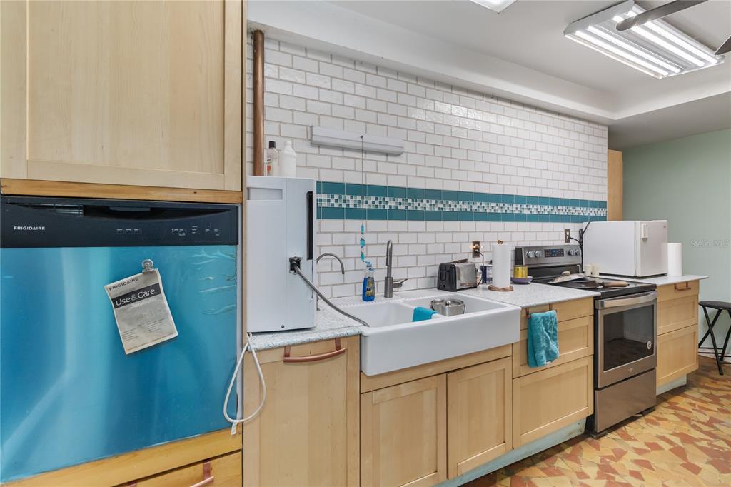 1730 Neptune Road Kissimmee, FL 34744 - Photo 11 of 38 a kitchen with stainless steel appliances granite countertop a sink and a stove