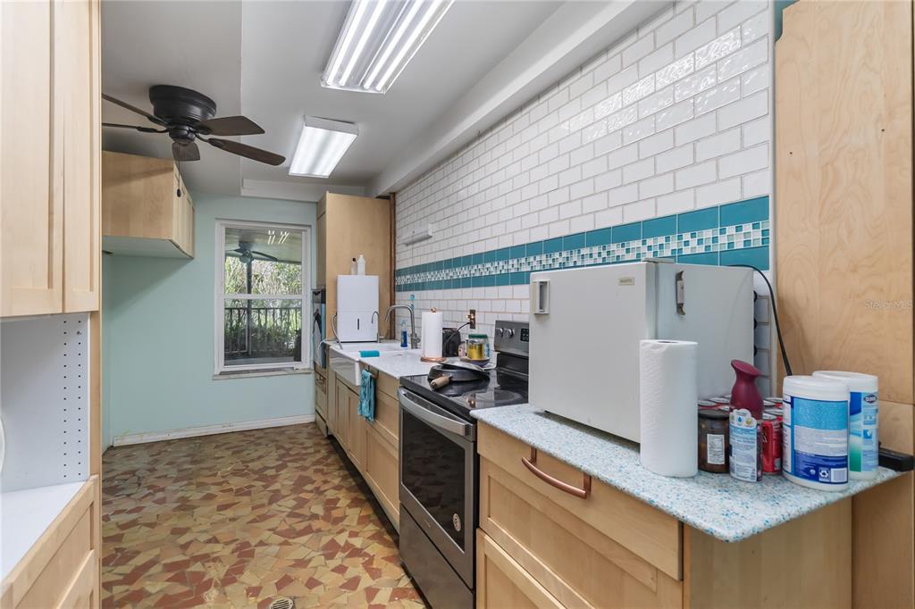 1730 Neptune Road Kissimmee, FL 34744 - Photo 12 of 38 a kitchen with granite countertop a stove and a refrigerator