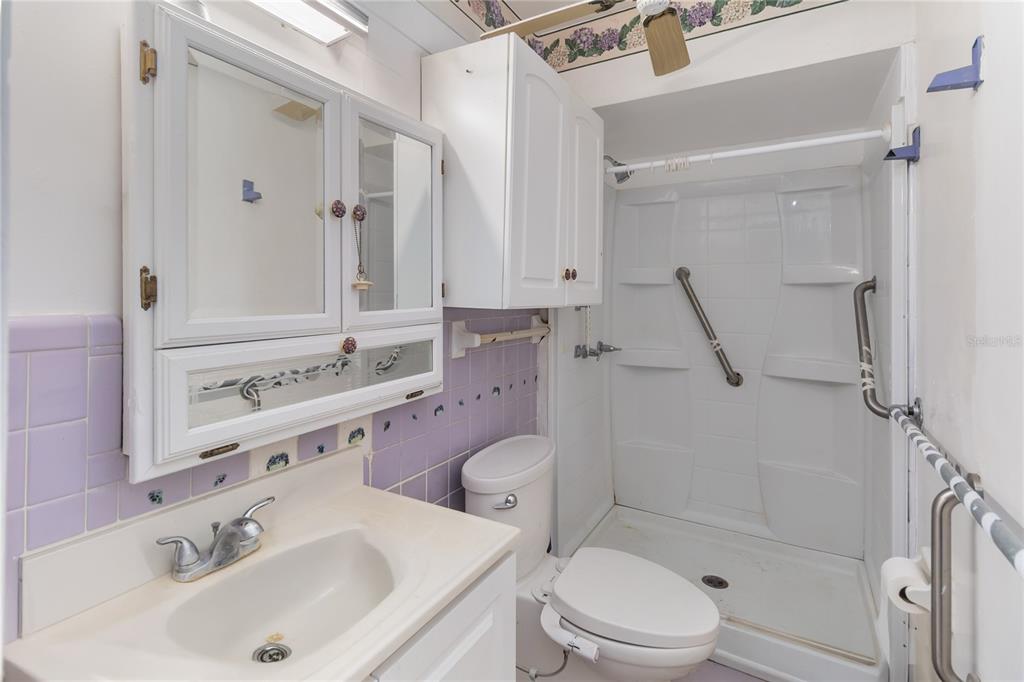 1730 Neptune Road Kissimmee, FL 34744 - Photo 17 of 38 a bathroom with a sink toilet vanity and shower