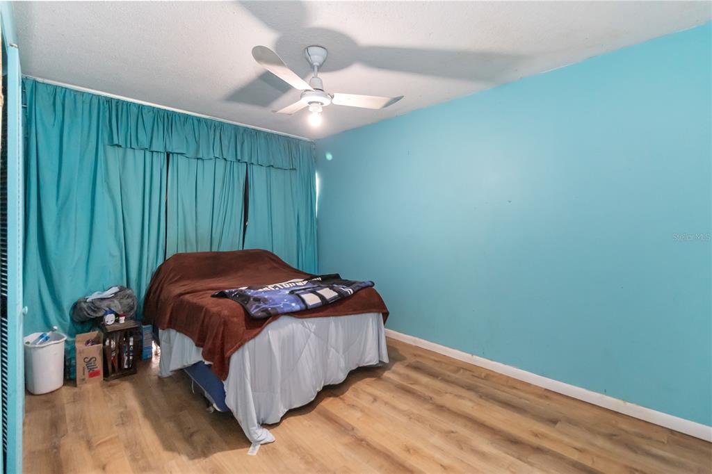 1730 Neptune Road Kissimmee, FL 34744 - Photo 18 of 38 a bedroom with a bed and a chandelier