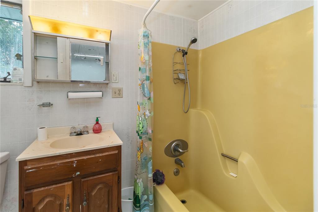 1730 Neptune Road Kissimmee, FL 34744 - Photo 28 of 38 a bathroom with a sink mirror and shower
