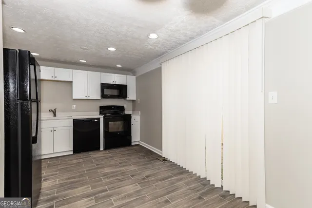 a kitchen with a refrigerator and a stove top oven
