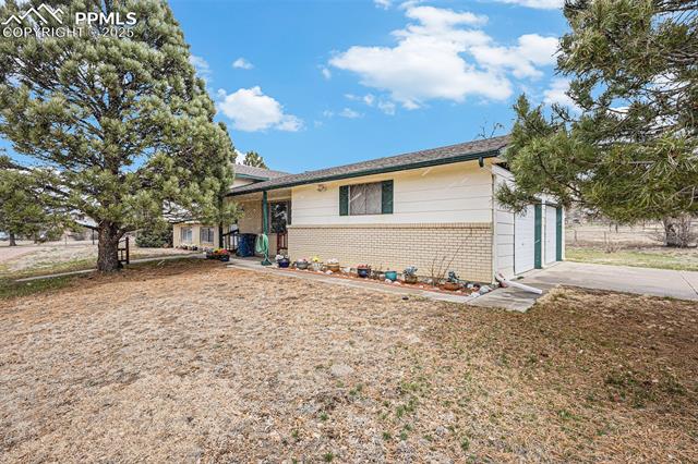 1653 Cragin Road Colorado Springs, CO 80920 - Photo 21 of 27 View of front facade featuring driveway, brick siding, and an attached garage