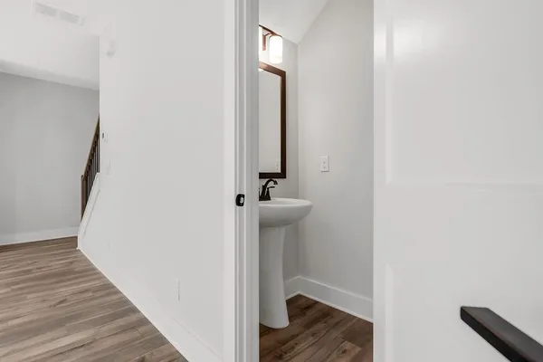 a view of a hallway with wooden floor and staircase