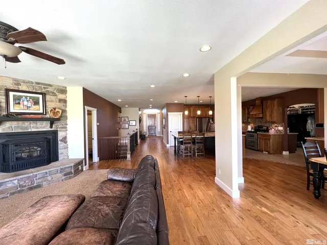 a living room with fireplace furniture and a ceiling fan