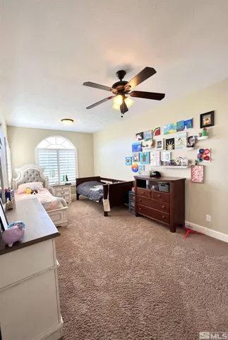 a work room with furniture a flat screen tv and a window