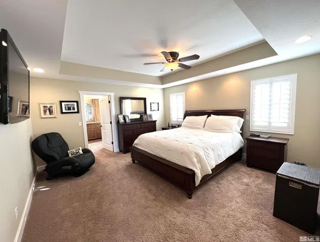 a spacious bedroom with a bed and a flat screen tv
