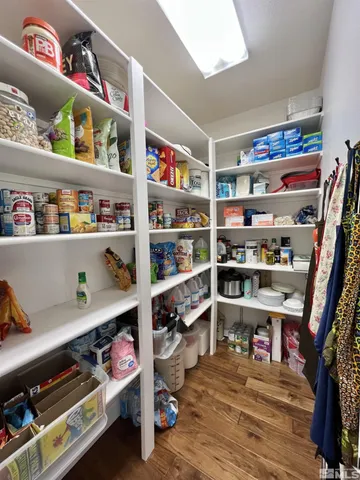 a kitchen with stainless steel appliances granite countertop a stove top oven a sink dishwasher a dining table and chairs with wooden floor