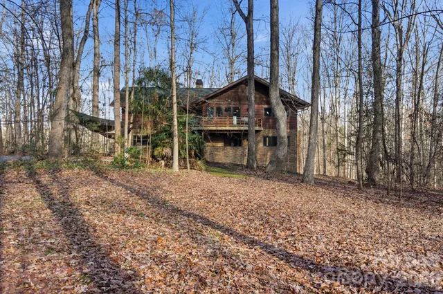 a view of a house with a yard and wooden fence