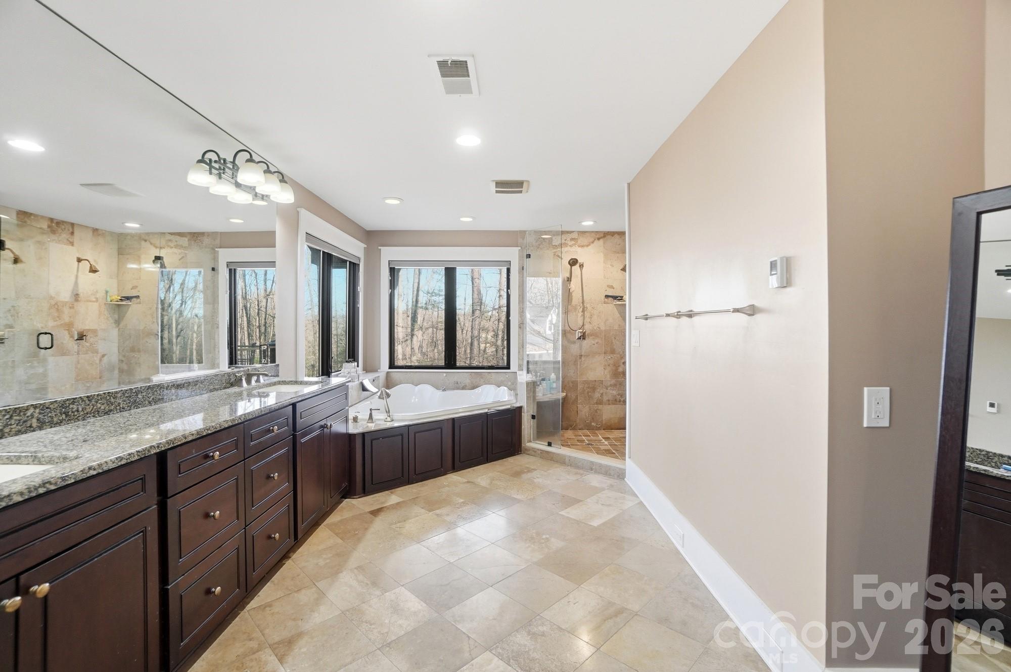 17928 Pages Pond Court Davidson, NC 28036 - Photo 23 of 48 a large bathroom with a double vanity sink a large mirror and shower