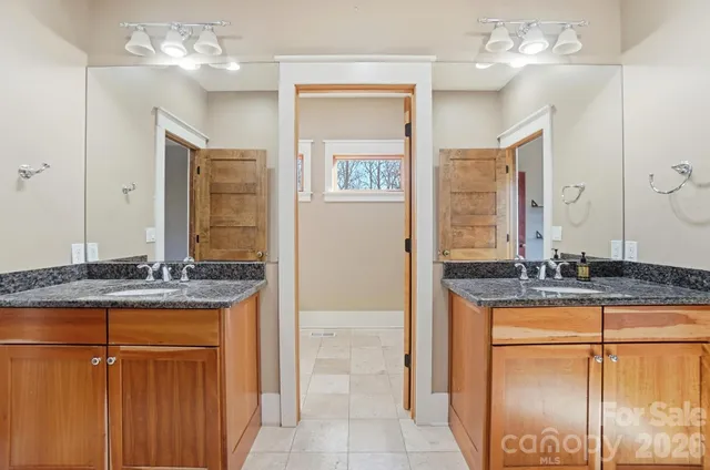 a bathroom with a granite countertop sink a mirror and a shower