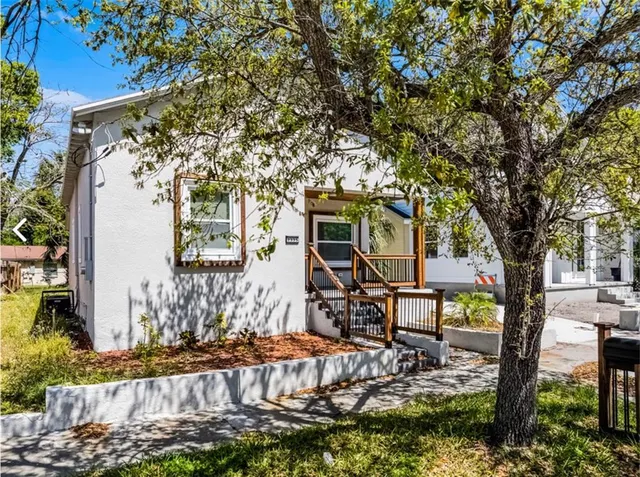 a view of a house with backyard and sitting area