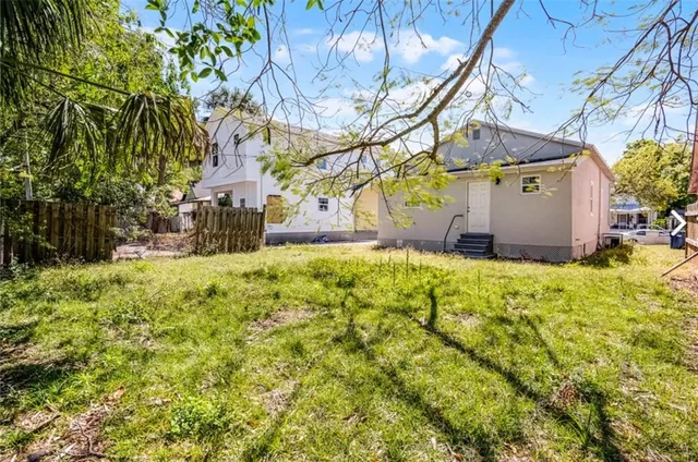 a view of a yard with plants and large trees