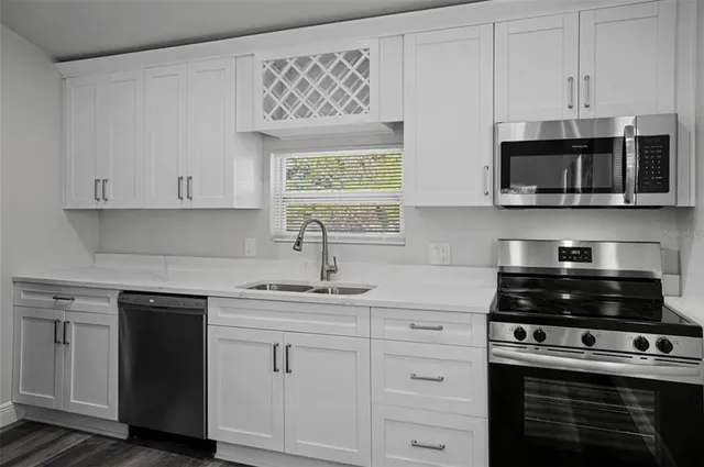 a kitchen with white cabinets and appliances