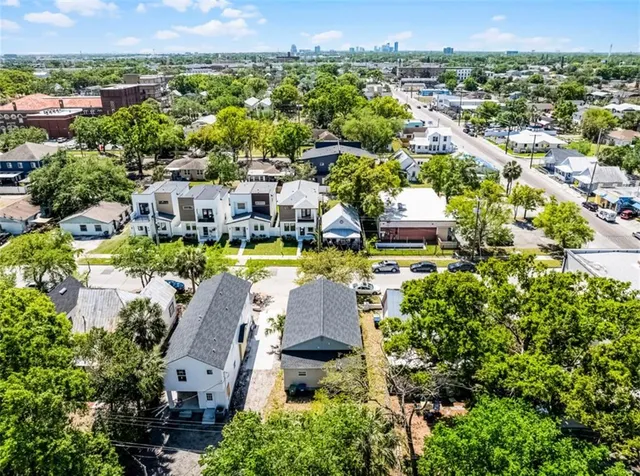 an aerial view of residential houses with outdoor space and swimming pool