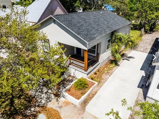a aerial view of a house with a yard and potted plants