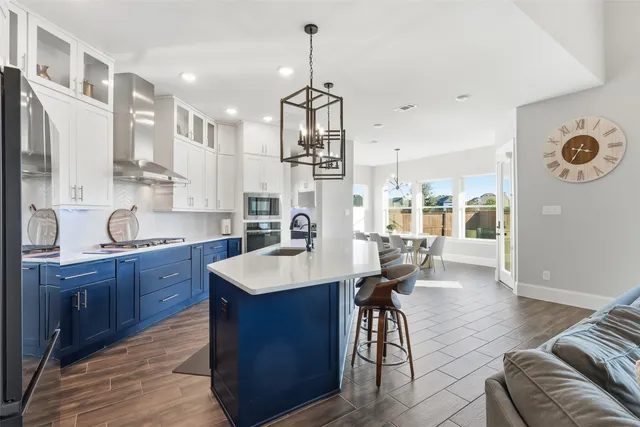 a large kitchen with cabinets a sink a window and stainless steel appliances