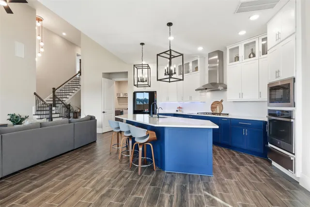 a kitchen with stainless steel appliances kitchen island granite countertop a table chairs sink and cabinets