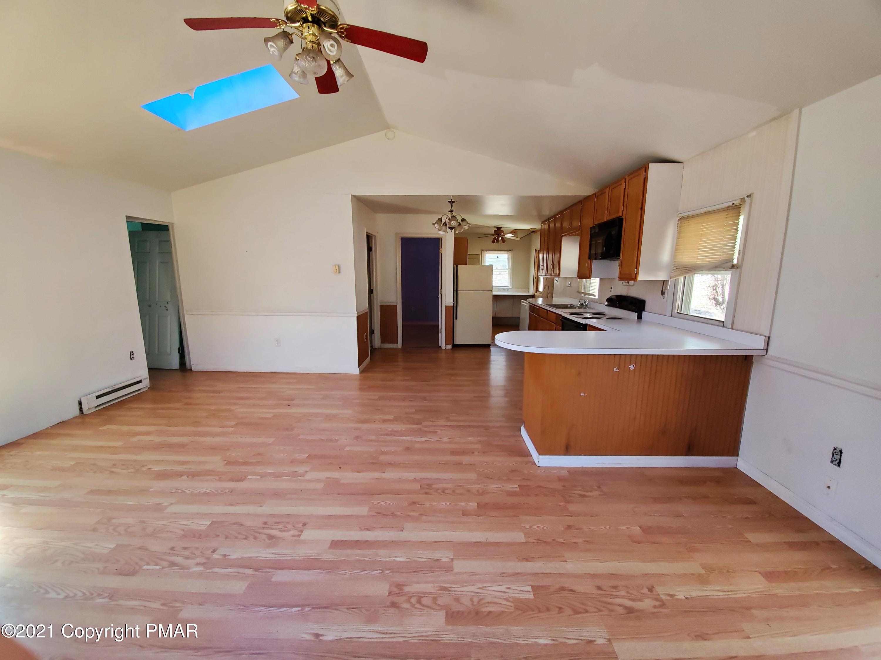 1112 Fir Road Effort, PA 18330 - Photo 3 of 8 a view of a kitchen with kitchen island a counter top space a sink and wooden floor