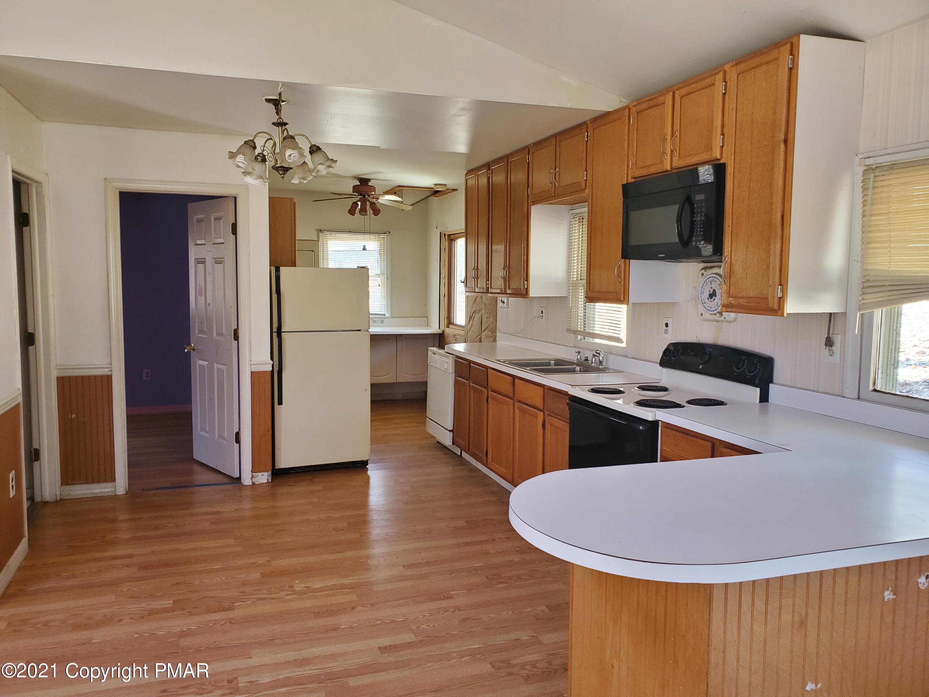 1112 Fir Road Effort, PA 18330 - Photo 4 of 8 a kitchen with stainless steel appliances granite countertop a stove top oven a sink dishwasher and a refrigerator with wooden floor