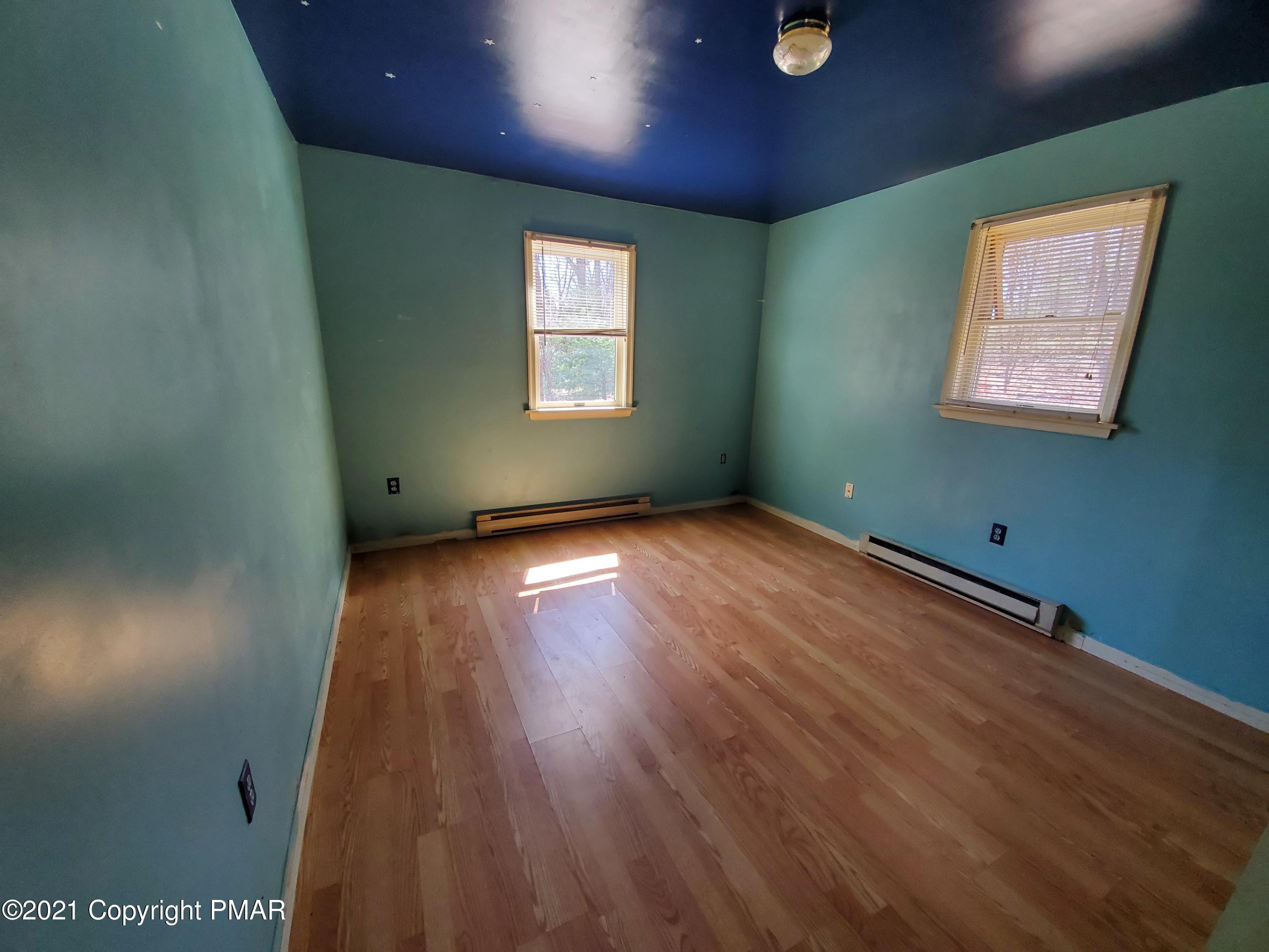 1112 Fir Road Effort, PA 18330 - Photo 6 of 8 an empty room with wooden floor and windows