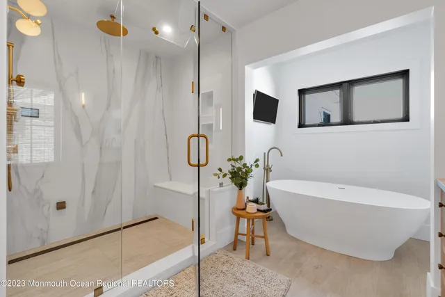 a bathroom with a toilet a sink a glass door a shower and mirror