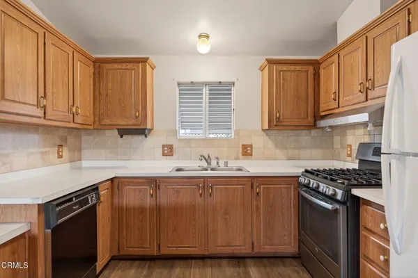 a kitchen with stainless steel appliances granite countertop a sink stove and cabinets