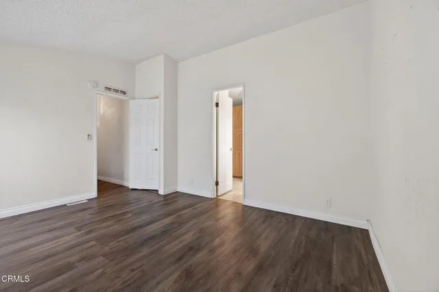 an empty room with wooden floor and closet