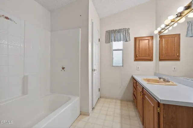 a bathroom with a sink a mirror and a bathtub