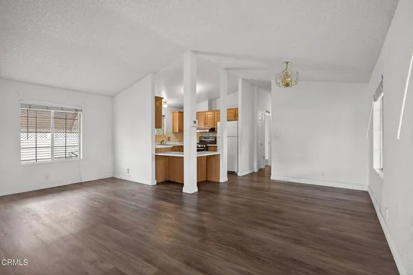 an empty room with wooden floor closet and windows