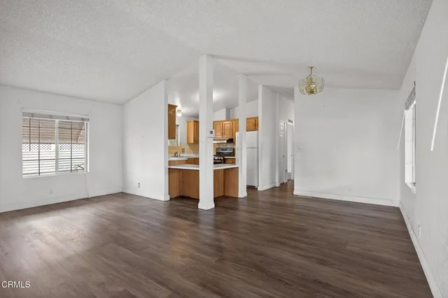 an empty room with wooden floor closet and windows