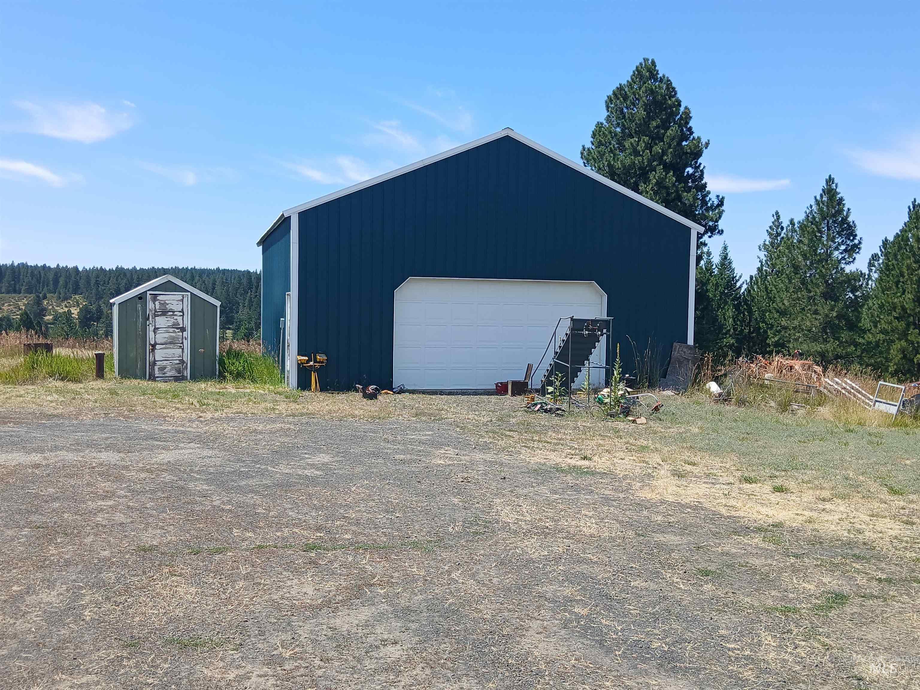 1076 Headrick Road Potlatch, ID 83855 - Photo 2 of 8 Metal-sided outbuilding featuring a white garage door, white trim, and an exterior staircase