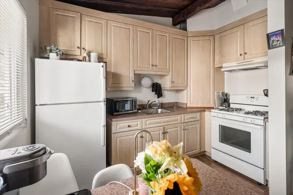 a kitchen with stainless steel appliances white cabinets a stove a sink and a refrigerator