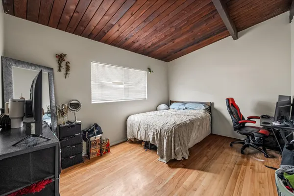 a bedroom with a bed and wooden floor