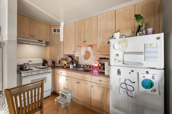 a kitchen with white cabinets and white appliances