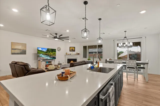 a view of a dining room and livingroom with furniture wooden floor a chandelier