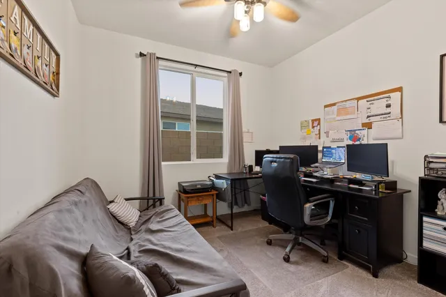 a view of a workspace with furniture and a window