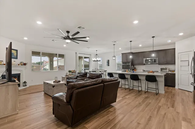 a living room with stainless steel appliances kitchen island furniture and a flat screen tv