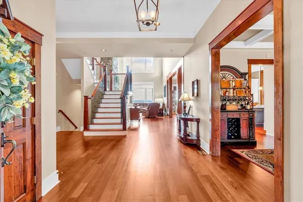 a open kitchen with stainless steel appliances granite countertop a stove top oven a refrigerator a sink and white cabinets with wooden floor