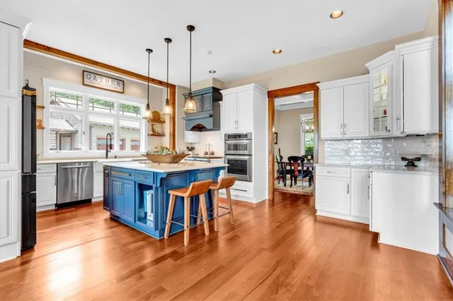 a kitchen with stainless steel appliances cabinets a large window and a sink